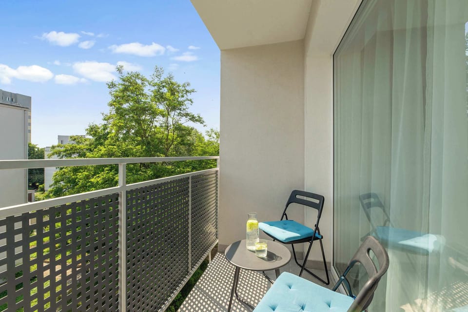 Z salonu prowadzi bezpośrednie wyjście na balkon z widokiem na spokojne osiedle, co stanowi idealne miejsce na poranny relaks na świeżym powietrzu.