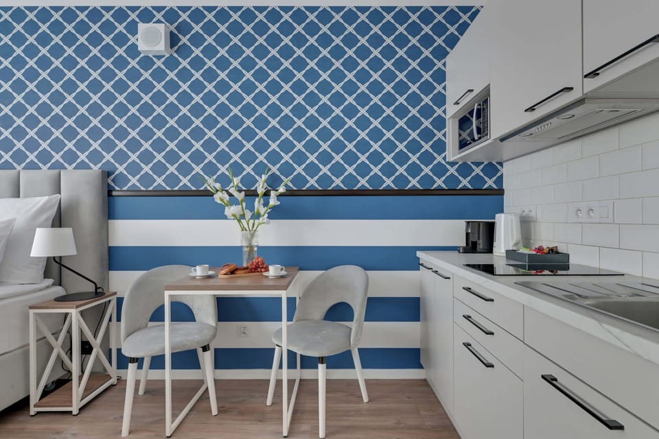Apartament wyposażony jest w funkcjonalny aneks kuchenny, który umożliwia wygodne przygotowywanie posiłków. Do dyspozycji gości są płyta indukcyjna, mikrofala, lodówka, zmywarka, pralka, ekspres do kawy oraz czajnik. 