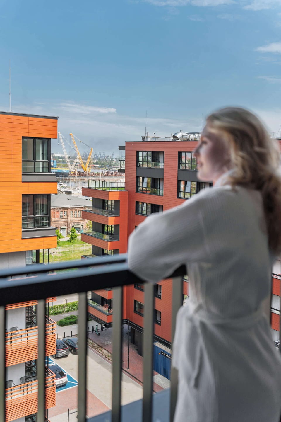 Z apartamentu można wyjść na balkon z widokiem na nowoczesne osiedle. Balkon został wyposażony w meble ogrodowe, dzięki czemu stanowi dodatkową przestrzeń do wypoczynku na świeżym powietrzu.