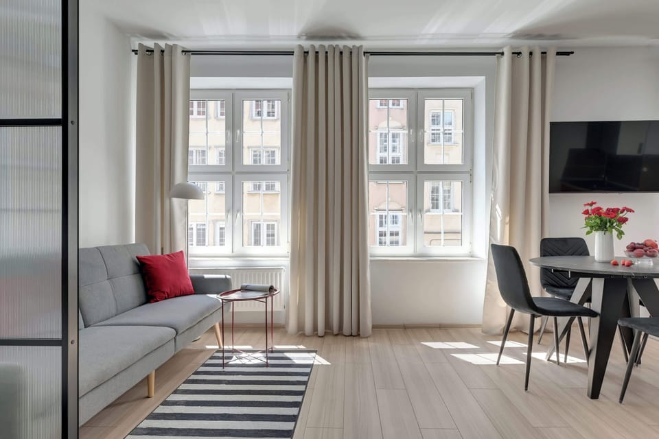 Stylowe i przestronne wnętrze łączy nowoczesny design z komfortem wypoczynku. Jasna część dzienna z wygodnym łóżkiem, sofą i strefą jadalnianą tworzy idealne miejsce na relaks po dniu spędzonym na odkrywaniu uroków Gdańska.