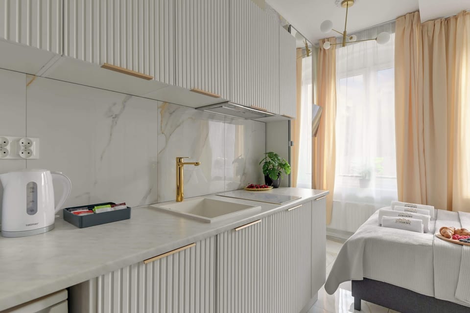 Pierwszą część apartamentu stanowi przytulna strefa typu studio. Znajduje się tu wygodne łóżko małżeńskie, telewizor z funkcją Smart TV, aneks kuchenny wyposażony w płytę indukcyjną oraz pralkę. 