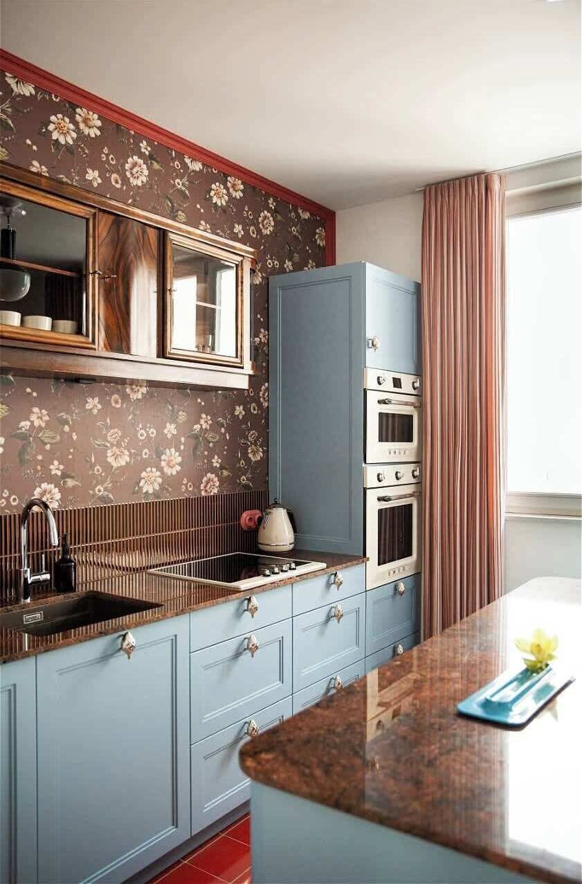 The separate kitchen combines functionality with unique design. Blue fronts, wooden elements, decorative wallpaper, and stylish details create an impressive interior. It is fully equipped with an induction cooktop, dishwasher, and microwave oven, wit