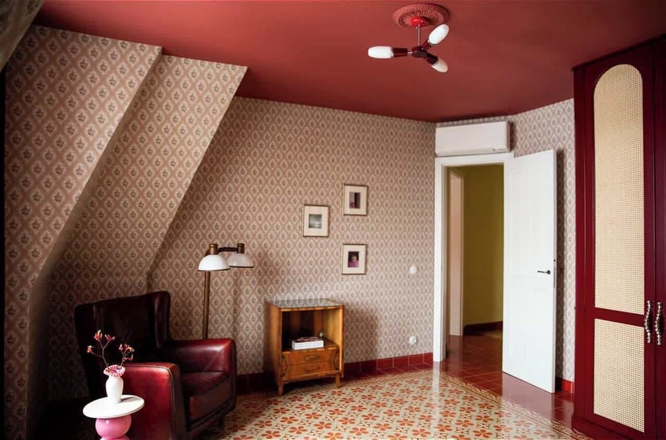 The first bedroom is equipped with a comfortable double bed and is decorated in an elegant, slightly theatrical style – with decorative wallpaper, ambient lighting, stylish curtains, and a cozy relaxation area.