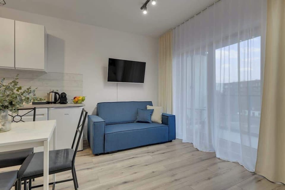 Komfortowe studio oferuje wygodne łóżko małżeńskie ustawione naprzeciw telewizora z kanałami kablowymi i funkcją Smart TV, tworząc idealne miejsce do relaksu po dniu zwiedzania. Duże okna zapewniają piękne doświetlenie wnętrza oraz widok na okolicę.