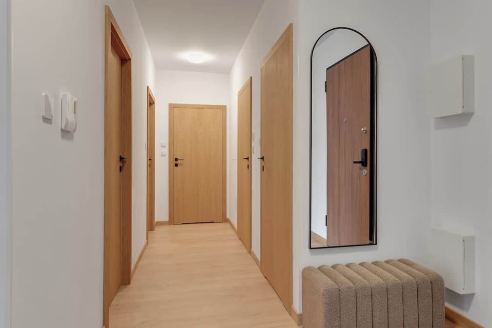 Centralnym punktem jest przestronny salon wyposażony w dwie rozkładane sofy, tworzące idealne miejsce do relaksu, a naprzeciw nich znajduje się telewizor z dostępem do kanałów i funkcją Smart TV. 