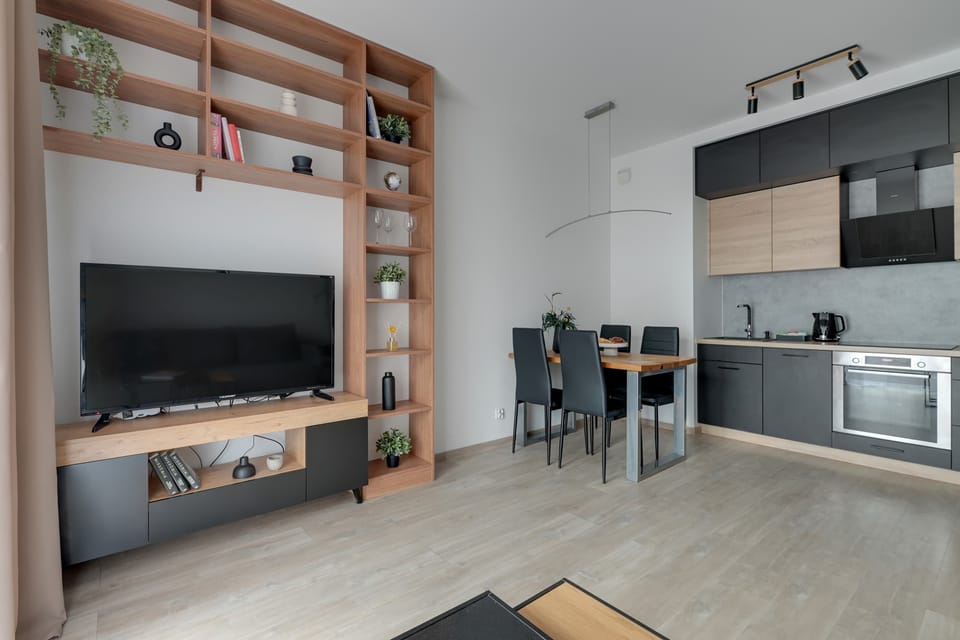 Przestronny salon oferuje rozkładaną sofę, telewizor Smart TV oraz jasne, dobrze doświetlone wnętrze sprzyjające wypoczynkowi.