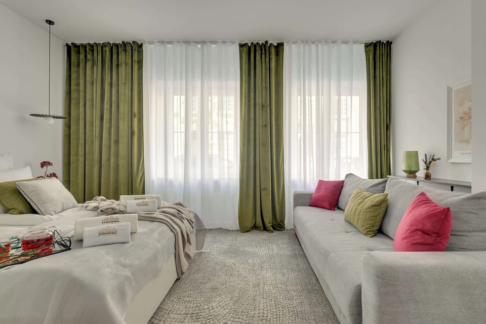 W części wypoczynkowej znajduje się wygodne łóżko dwuosobowe oraz rozkładana sofa, dzięki czemu apartament może komfortowo ugościć do czterech osób. To idealne miejsce do odpoczynku po dniu spędzonym na zwiedzaniu miasta.
