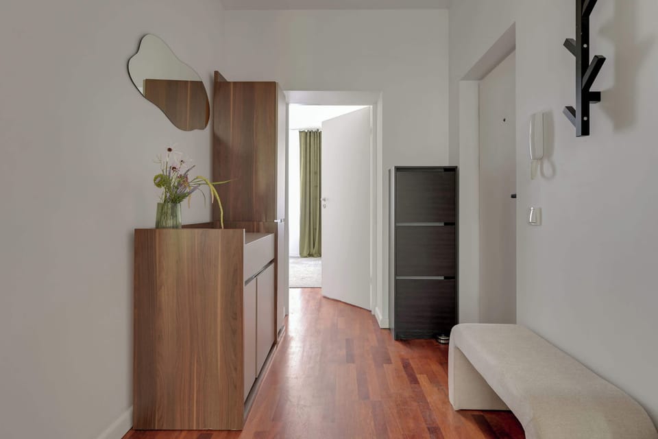 W części wypoczynkowej znajduje się wygodne łóżko dwuosobowe oraz rozkładana sofa, dzięki czemu apartament może komfortowo ugościć do czterech osób. To idealne miejsce do odpoczynku po dniu spędzonym na zwiedzaniu miasta.