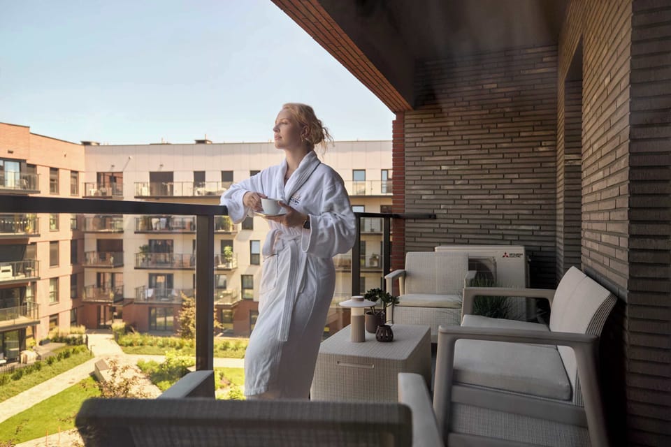 Apartament posiada balkon z meblami ogrodowymi, który stanowi dodatkową przestrzeń do wypoczynku. To idealne miejsce na poranną kawę, spokojny wieczór lub chwilę relaksu na świeżym powietrzu.