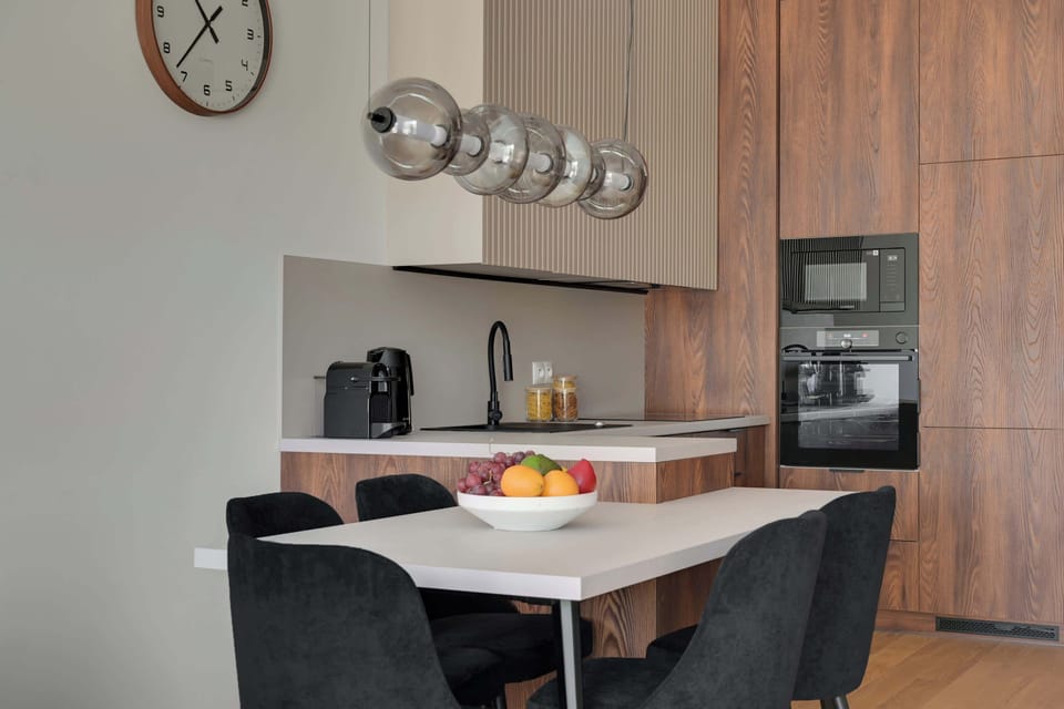 Elegancka kuchnia w nowoczesnym stylu zachwyca połączeniem naturalnego drewna, minimalistycznych form i wysokiej jakości wykończenia. W pełni wyposażona przestrzeń zapewnia komfort zarówno podczas krótkiego, jak i dłuższego pobytu.