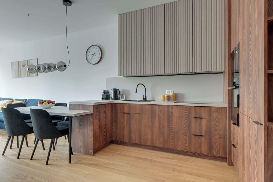 Elegancka kuchnia w nowoczesnym stylu zachwyca połączeniem naturalnego drewna, minimalistycznych form i wysokiej jakości wykończenia. W pełni wyposażona przestrzeń zapewnia komfort zarówno podczas krótkiego, jak i dłuższego pobytu.