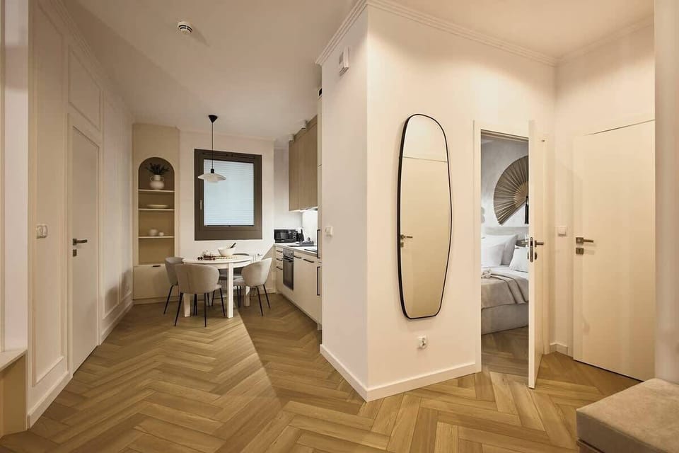 Przytulny salon z rozkładaną sofą to idealne miejsce do wspólnego wypoczynku – wygodny narożnik, designerski stolik i duży telewizor tworzą domowy klimat. Jasne ściany, miękkie tekstylia i eleganckie dodatki sprzyjają relaksowi po dniu pełnym wrażeń.