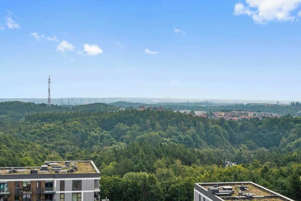 Z salonu prowadzi wyjście na prywatny balkon z kojącym widokiem na las, idealny do porannej kawy lub wieczornego odpoczynku.