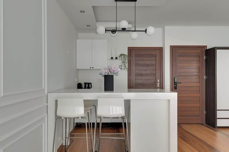 Apartament posiada aneks kuchenny z płytą, czajnikiem i ekspresem do kawy, stół jadalniany z funkcją miejsca do pracy oraz zestaw powitalny z kawą, herbatą i podstawowymi przyprawami.