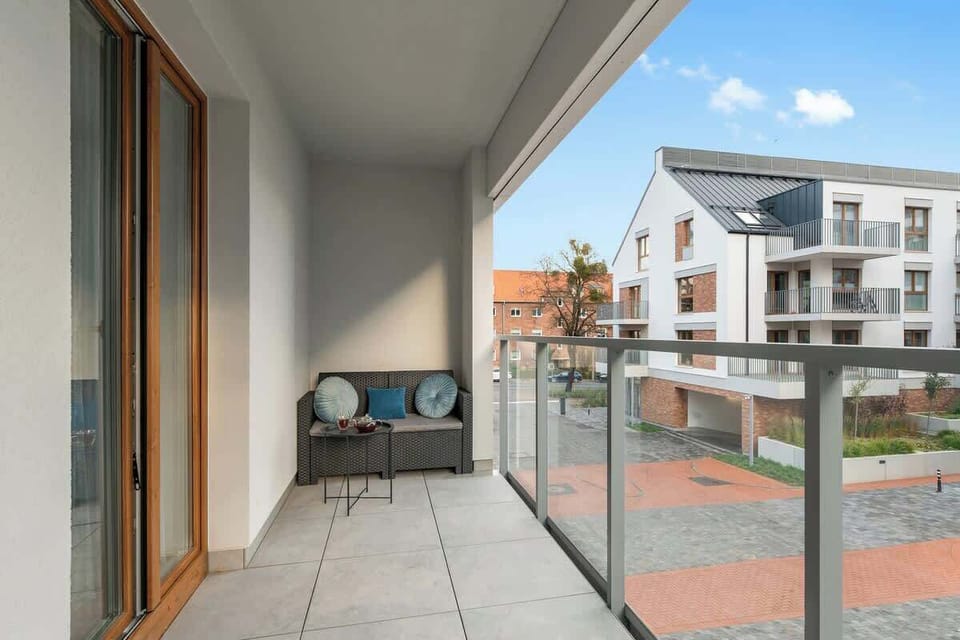 Z salonu można wyjść na balkon z wygodnym zestawem wypoczynkowym – doskonałe miejsce na poranną kawę lub wieczorny relaks.
