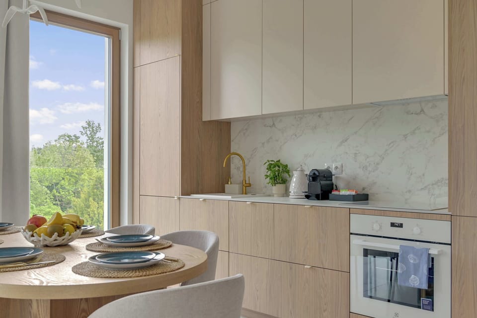 Nowoczesna kuchnia została w pełni wyposażona we wszystkie niezbędne sprzęty, takie jak piekarnik, płyta indukcyjna, zmywarka, lodówka, ekspres do kawy oraz czajnik. 