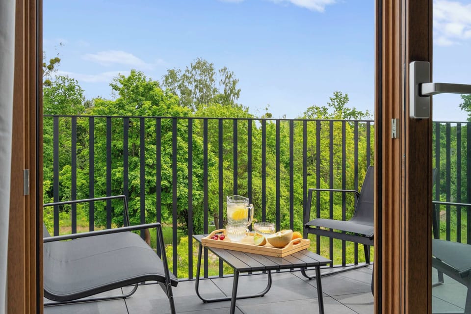 Z salonu można wyjść na balkon wyposażony w meble wypoczynkowe – idealne miejsce na poranną kawę lub wieczorny odpoczynek.