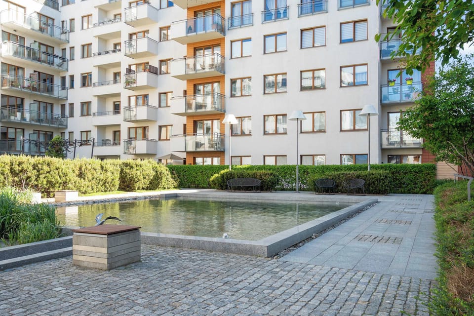 Nowoczesne osiedle oferuje zadbane części wspólne z zielenią, przestrzenią do odpoczynku oraz elegancką architekturą. Spokojne otoczenie i estetyczne patio tworzą przyjemną atmosferę zarówno na krótki, jak i dłuższy pobyt.