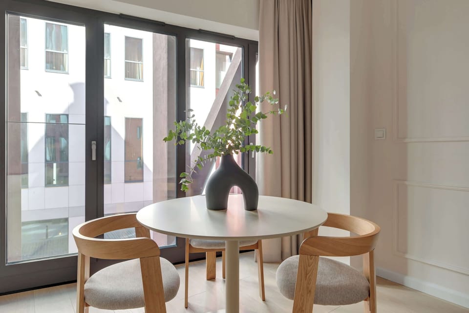 Główną część apartamentu stanowi otwarta przestrzeń łącząca salon i sypialnię. Znajduje się tu wygodne łóżko małżeńskie, sofa oraz telewizor z funkcją Smart TV.