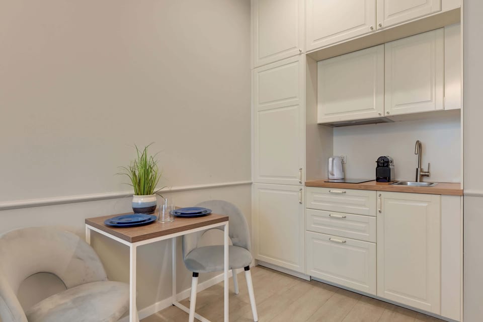 Apartament oferuje aneks kuchenny z niezbędnym wyposażeniem, stół z krzesłami oraz zestaw powitalny z kawą, herbatą i przyprawami.