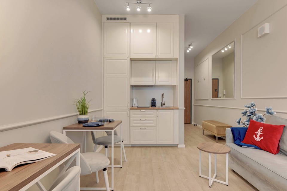 Apartament oferuje aneks kuchenny z niezbędnym wyposażeniem, stół z krzesłami oraz zestaw powitalny z kawą, herbatą i przyprawami.