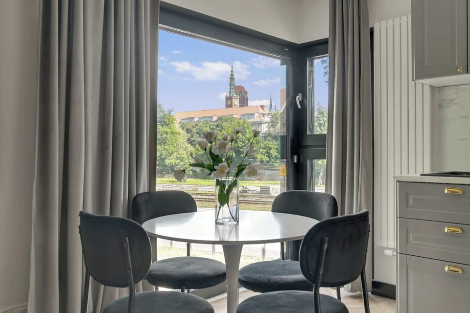 Głównym pomieszczeniem apartamentu jest przestronny salon, który pełni funkcję zarówno strefy wypoczynkowej, jak i jadalnianej. Znajduje się w nim wygodna rozkładana sofa, zapewniająca dodatkowe miejsce do spania. 