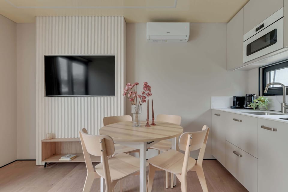 W sercu domku znajduje się funkcjonalny aneks kuchenny, który łączy estetykę z wygodą. Jasne fronty szafek, nowoczesne wyposażenie i minimalistyczny design sprawiają, że gotowanie nawet prostych posiłków staje się przyjemnością. 