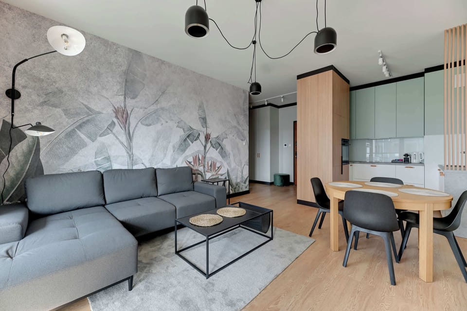 Sercem apartamentu jest przestronny salon z wygodną, rozkładaną sofą z funkcją spania, stolikiem kawowym oraz telewizorem Smart TV z dostępem do kanałów kablowych.