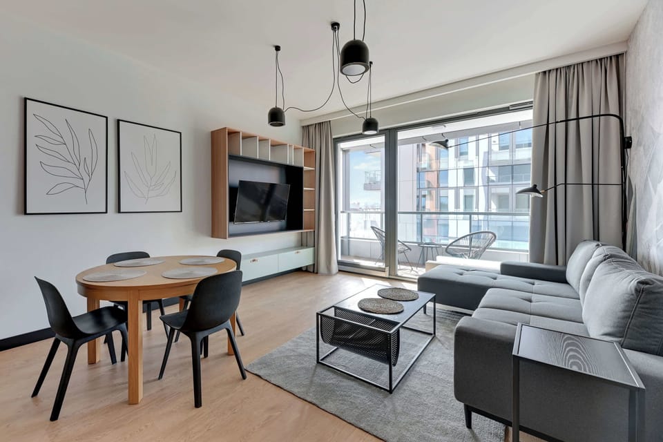 Sercem apartamentu jest przestronny salon z wygodną, rozkładaną sofą z funkcją spania, stolikiem kawowym oraz telewizorem Smart TV z dostępem do kanałów kablowych.