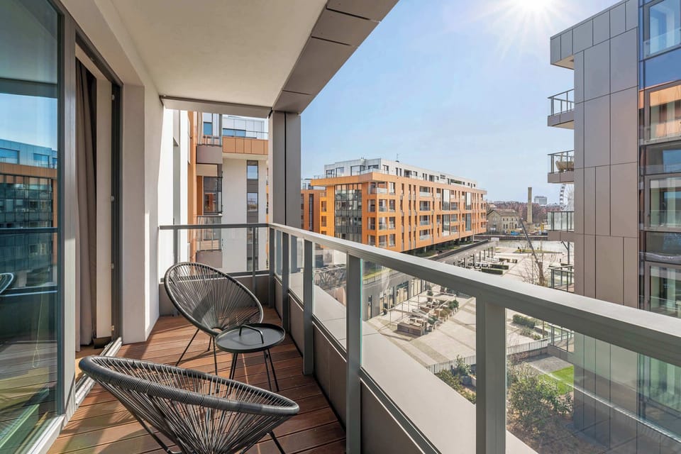 Z salonu można wyjść na balkon z miejscem do wypoczynku i ładnym widokiem na wewnętrzny dziedziniec - doskonały na poranną kawę lub spokojny wieczór.