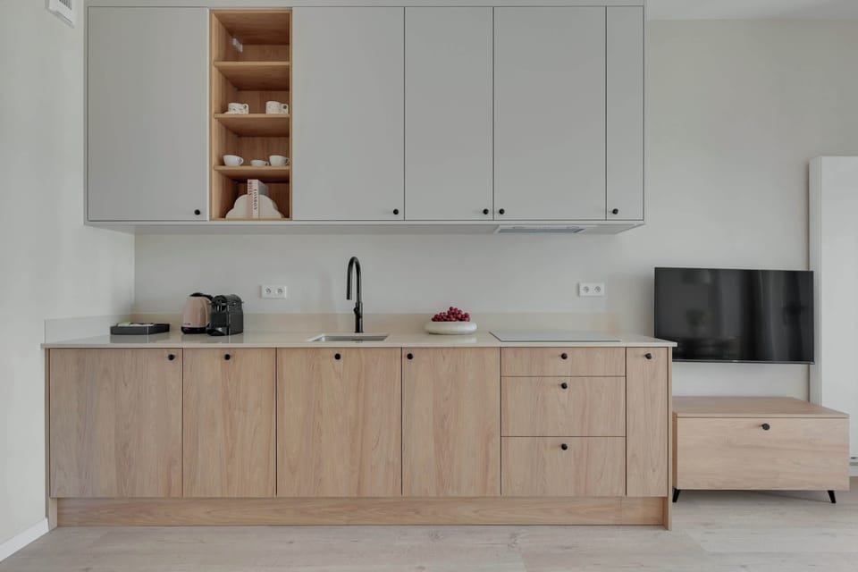 Nowoczesny aneks kuchenny został w pełni wyposażony z myślą o wygodnym pobycie. Jasne wnętrza i naturalne drewniane wykończenia tworzą elegancką, przytulną przestrzeń idealną do relaksu i wspólnego spędzania czasu.