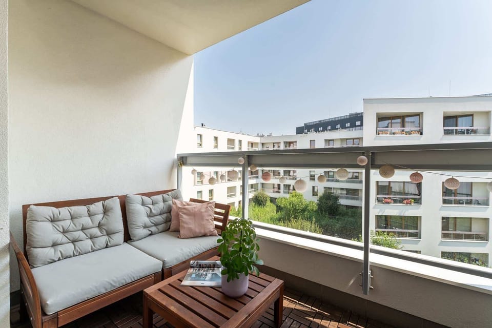 Duże przeszklenia zapewniają dostęp do naturalnego światła, a z salonu można wyjść bezpośrednio na balkon, który stanowi dodatkową przestrzeń do odpoczynku.
