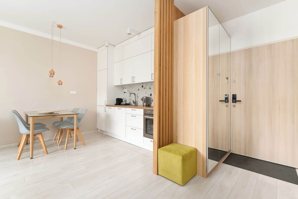 Centralną częścią apartamentu jest salon z rozkładaną sofą, telewizorem z kanałami kablowymi i funkcją Smart TV oraz wyjściem na balkon. Duże przeszklenia zapewniają wnętrzu dużo naturalnego światła.