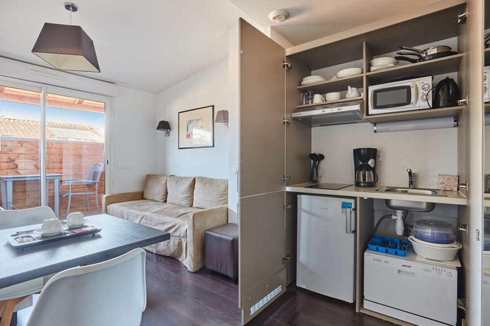 The fully equipped kitchenette includes a ceramic hob, dishwasher, microwave, and kettle, everything you need for a self-sufficient stay.