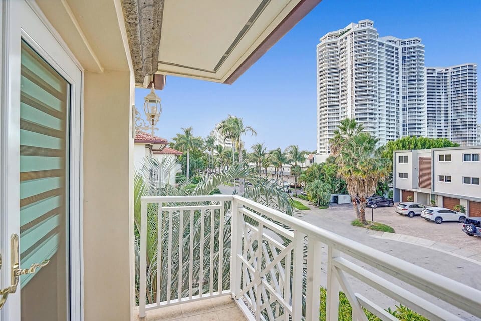 Private balcony overlooks the surrounding neighborhood and tropical scenery.