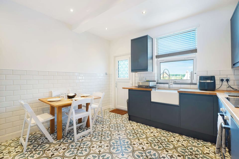 Featuring an oven, hob, dishwasher, air fryer, and a large fridge-freezer, this kitchen is a chef's dream. With extensive prep space, cookware, and storage, it is perfectly suited for quick breakfasts and elaborate family dinners alike.