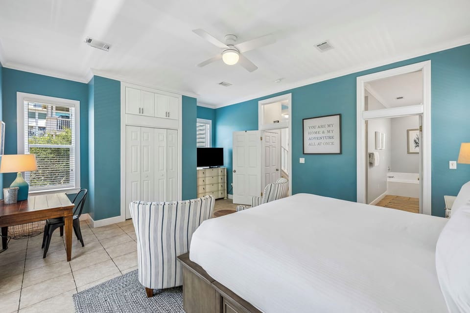 Unwind in your serene bedroom with calming blue walls, a plush bed, and a private en-suite. A ceiling fan keeps you cool while you relax.