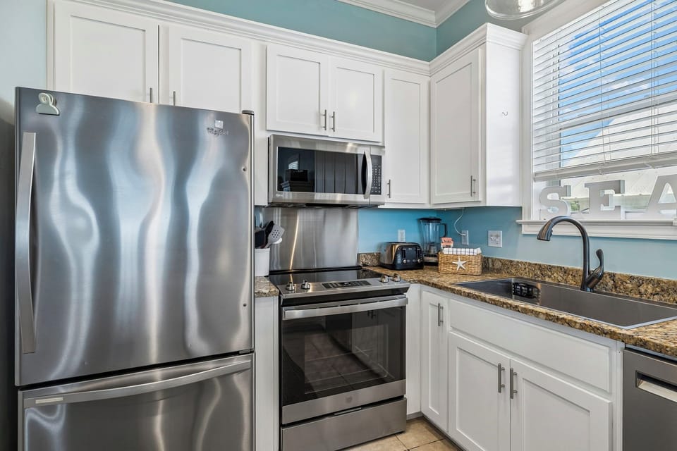 Step into your coastal-inspired kitchen with gleaming stainless appliances, granite counters, and crisp white cabinetry. Everything you need to whip up vacation meals in style.