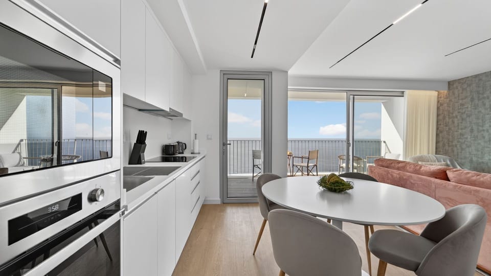 Kitchen with Sea View A sleek, fully equipped kitchen — brand new in 2026 — with the Atlantic as your permanent backdrop. #LuxenByLovelyStay #NewIn2026 #MadeiraApartment