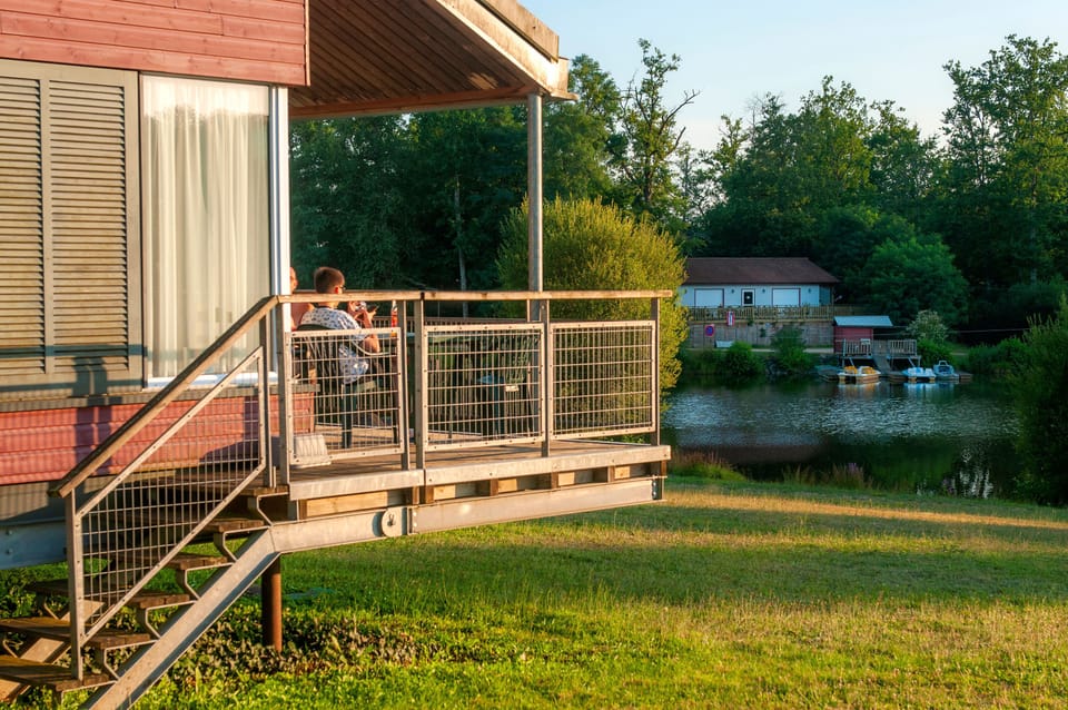 The pool at sunset, orange light reflected on the water and wooden decking.