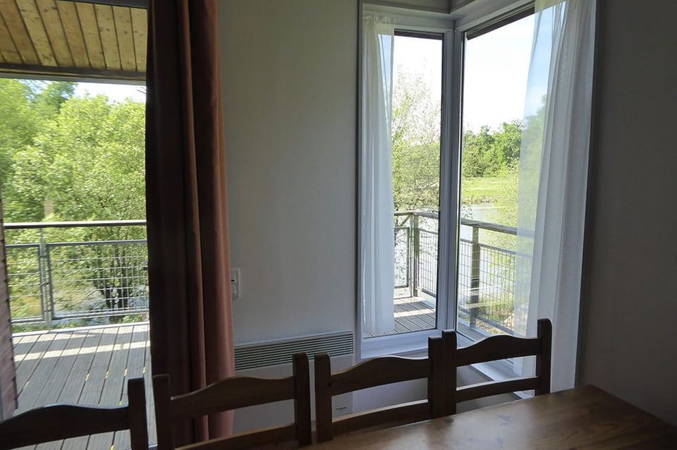 Wide windows in the dining area bring in the surrounding forest and light.