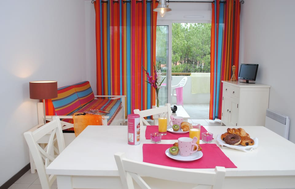 The open-plan layout keeps the whole group together, with a dining table, kitchenette, and easy access to the terrace.