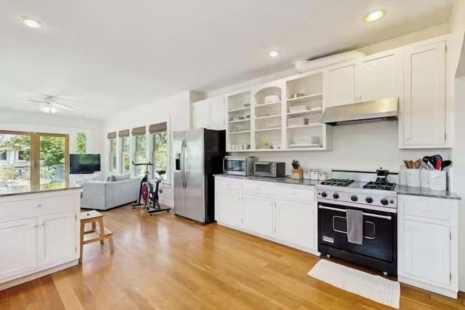 Spacious kitchen and dining area with warm hardwood floors and bright white finishes.