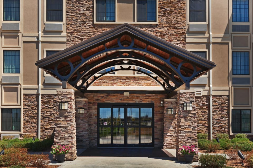 Covered entrance with stone archway and porte-cochere — drop-off and self-park are both available on-site