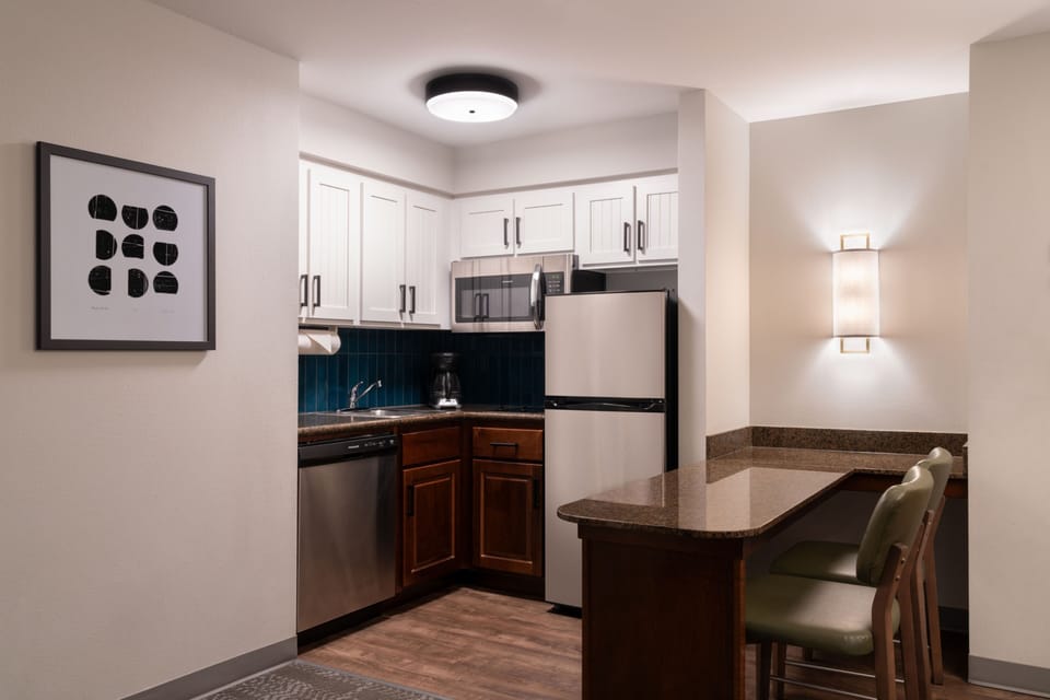 Fully equipped kitchen with stainless steel appliances and seating.