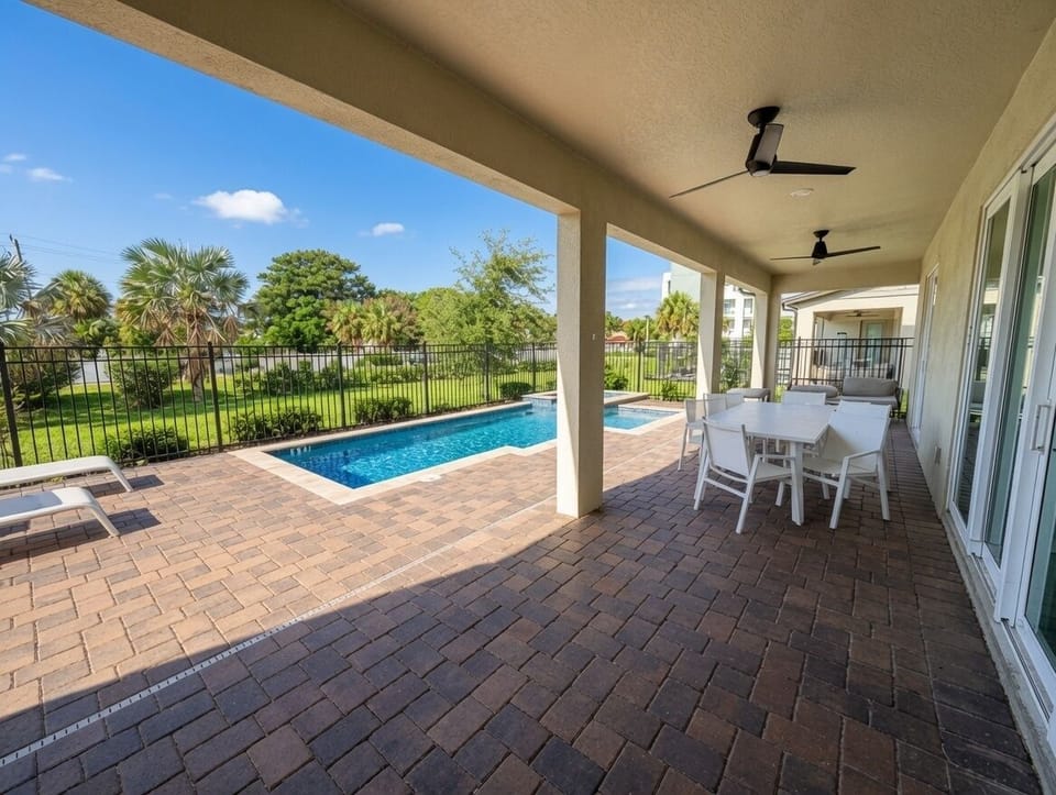 Covered lanai with private pool, outdoor dining, and serene green views