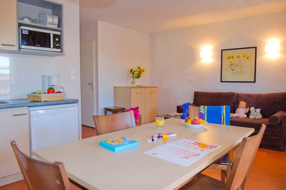 Living area with a sofa bed, TV unit, and dining table — the 40 m² cabin apartment gives the family room to spread out.