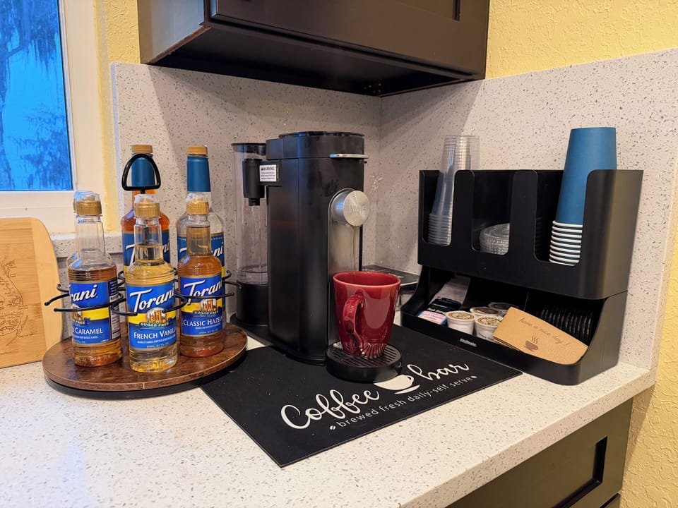 Coffee/tea bar stocked with specialty syrups and creamers