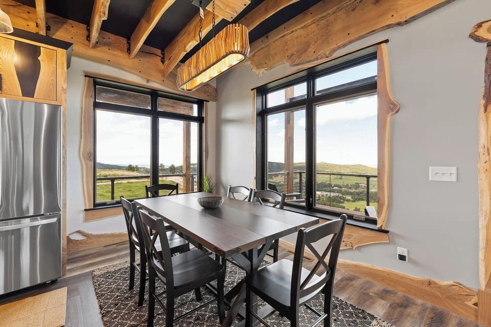 A bright dining area highlighted by two large windows that flood the space with natural light and offer a beautiful open view, creating an airy and inviting atmosphere.