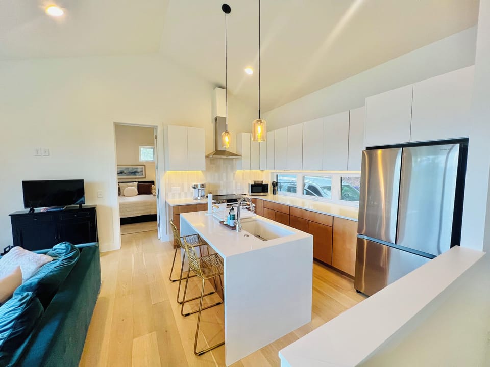 Cook, gather, and connect. This fully equipped kitchen features stainless steel appliances, modern finishes, a spacious island with seating, and plenty of room to prepare meals while staying connected to the rest of the group.